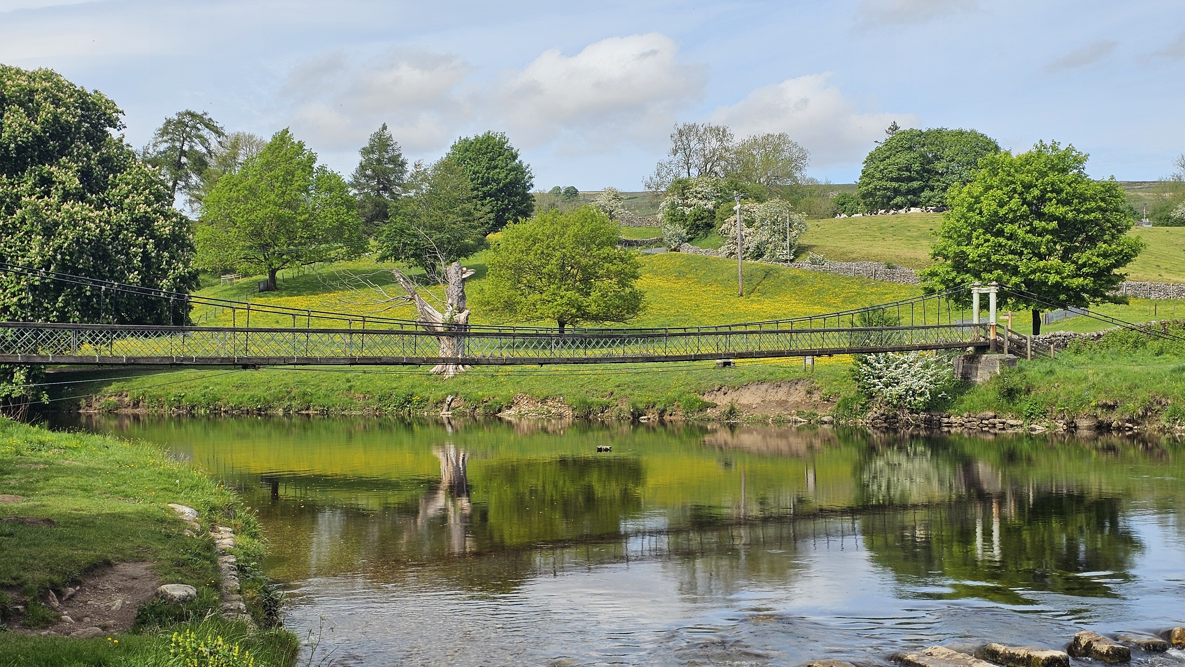 The Hebden suspension bridge over the River Wharfe, with the Dales rising behind