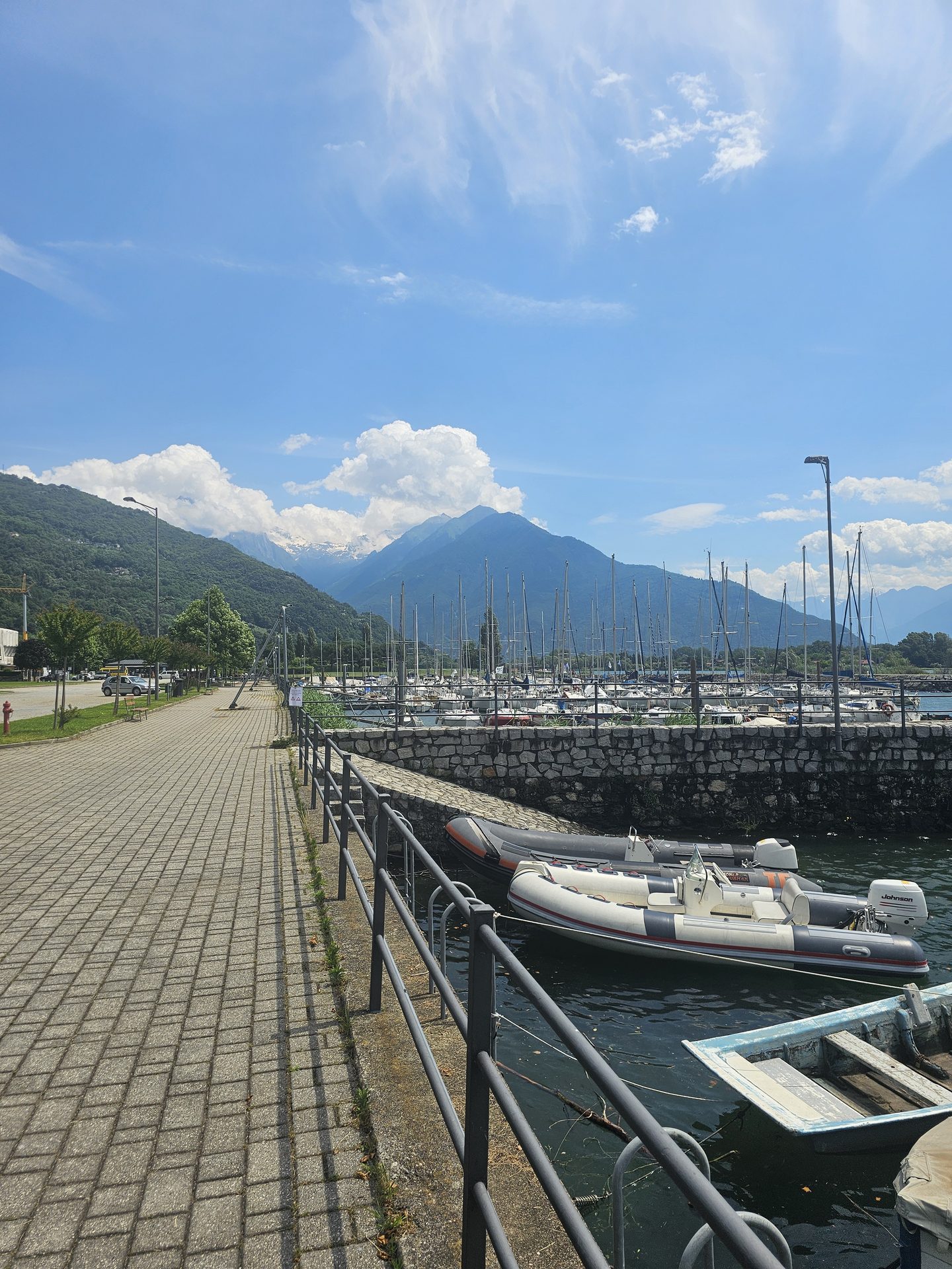 A lakeside promenade with moored boats at the northern end of Lake Como