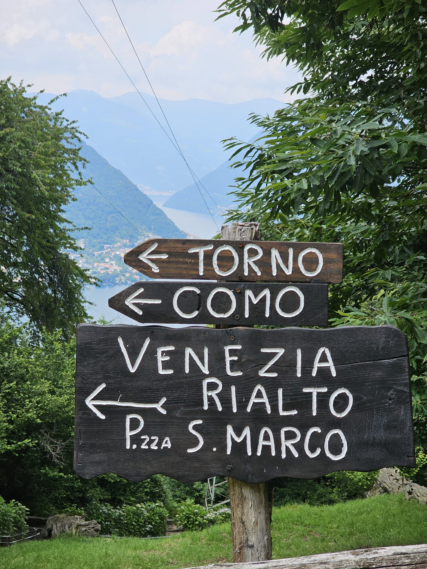 A weathered wooden fingerpost on the ridge pointing the way to Torno and Como
